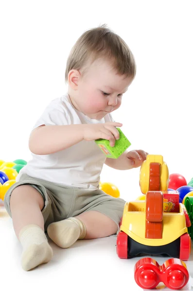 Маленький хлопчик грає в різнокольорові іграшки — стокове фото