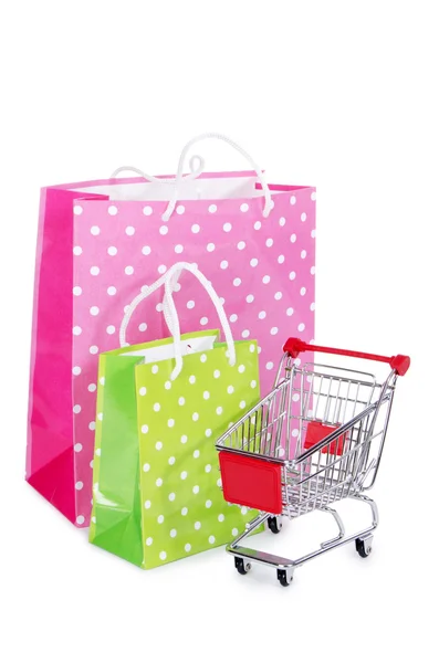 O carrinho de compras e sacos isolados em branco — Fotografia de Stock