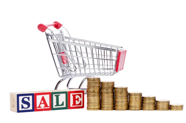 Coins in the form of the diagramme, shopping cart and word SALE — Stock Photo, Image