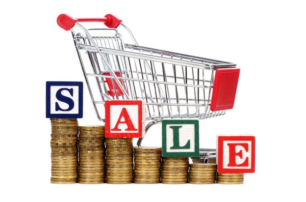 Coins in the form of the diagramme, shopping cart and word SALE — Stock Photo, Image