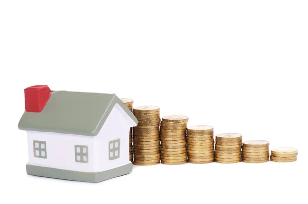 Toy small house and coins in the form of the diagram. concept — Stock Photo, Image