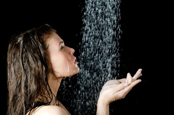 The girl under a shower on the black — Stock Photo, Image