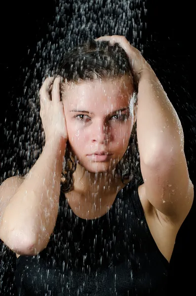 A menina abaixo de um chuveiro no preto — Fotografia de Stock