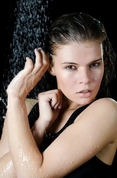 Das Mädchen unter der Dusche auf der schwarzen — Stockfoto