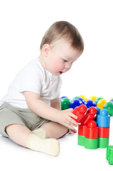 Маленький хлопчик грає в різнокольорові іграшки — стокове фото