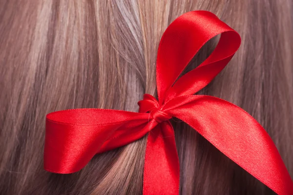 Arco vermelho em um cabelo — Fotografia de Stock