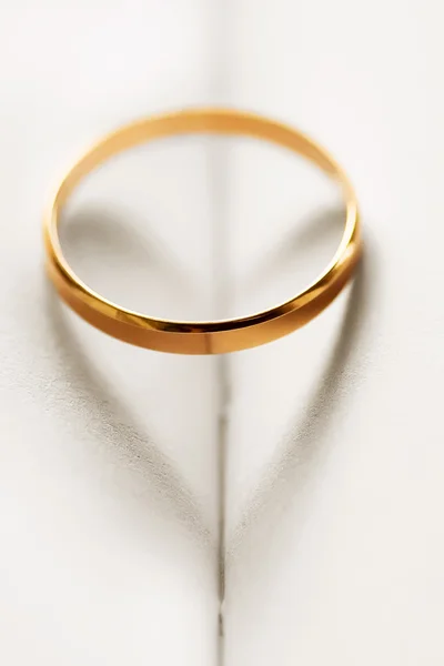 Anel de casamento lançando uma sombra em forma de coração — Fotografia de Stock