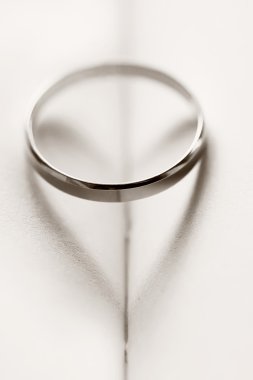 Wedding ring casting a heart-shaped shadow clipart