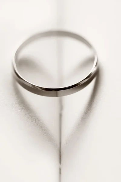 Anel de casamento lançando uma sombra em forma de coração — Fotografia de Stock