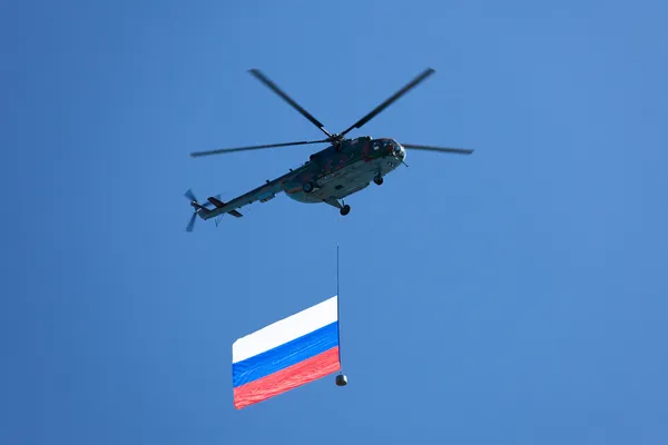 Helicopter in the skies carrying Russian flag — Stock Photo, Image