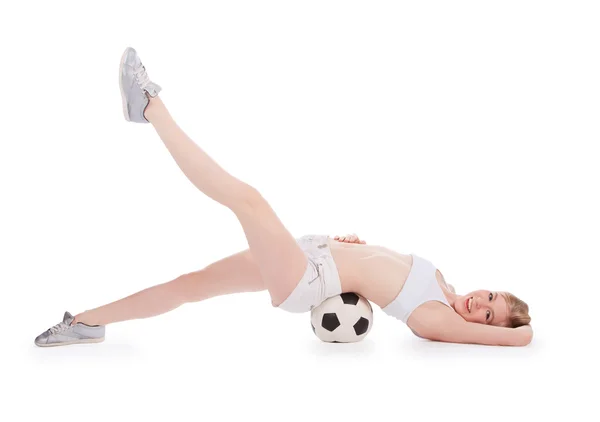 Teenager leží na podlaze s fotbalovým míčem přes bílý — Stock fotografie