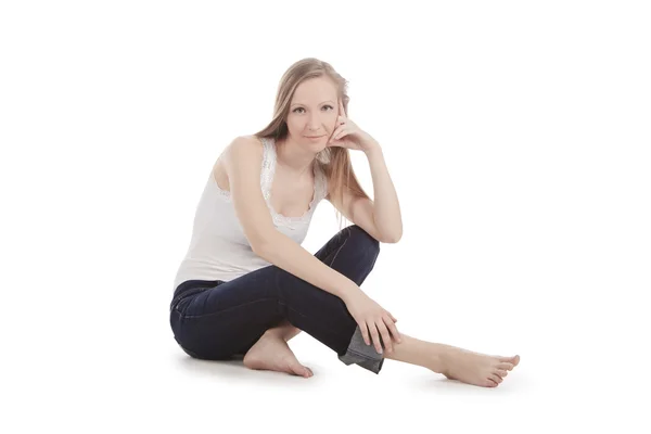 Mooie jonge vrouw zitten op een witte vloer barefoot — Stockfoto