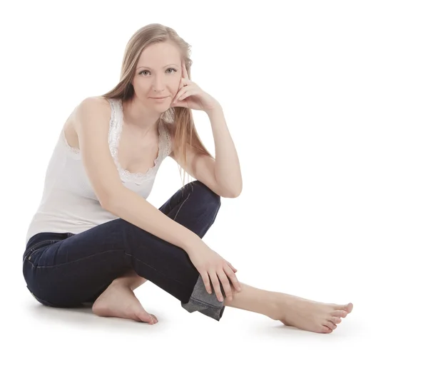 Vacker ung kvinna som sitter på ett vitt golv barfota — Stockfoto