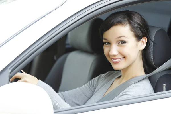 Lindo asiático hembra conductor en blanco coche sonriendo a usted . — Foto de Stock