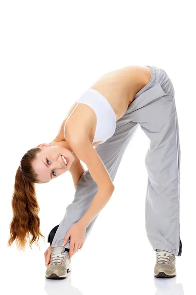 Mulher fazendo exercício de alongamento e sorrindo para você — Fotografia de Stock