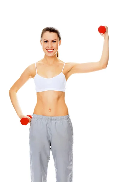 Mujer joven bastante feliz haciendo ejercicio con pesas libres —  Fotos de Stock