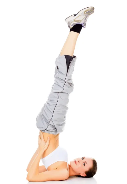 Menina saudável fazendo uma pose de ioga com os pés no ar — Fotografia de Stock