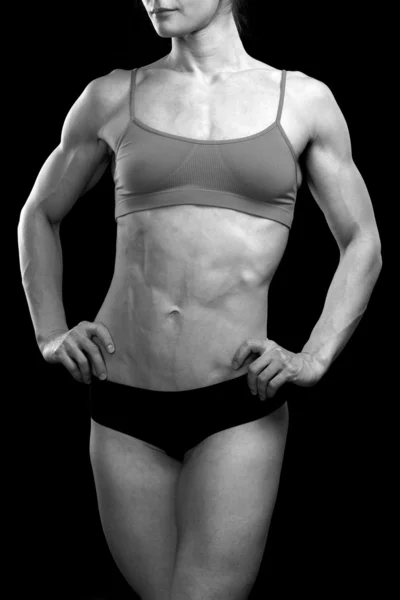 Muskulös kvinnliga kroppen mot svart bakgrund — Stockfoto