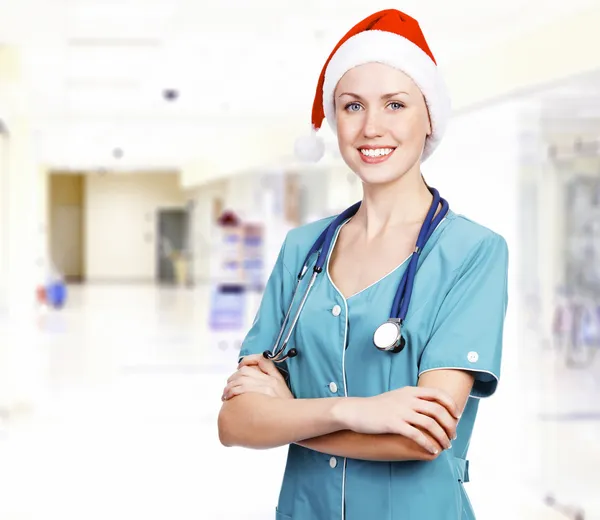 Smiling female medical doctor wearing red hat in a hall of a hos — Stock Photo, Image