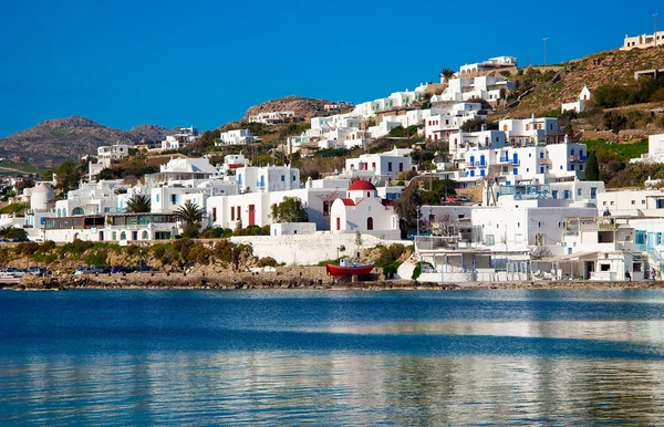 De beroemde rode boot en een kerk in de baai van mykonos. Griekenland. — Stockfoto