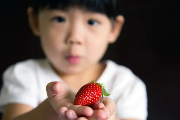 Happy little girl hold a strawberry — Stock Photo, Image