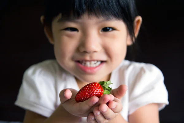 Dziewczynka szczęśliwy trzymać truskawka — Zdjęcie stockowe
