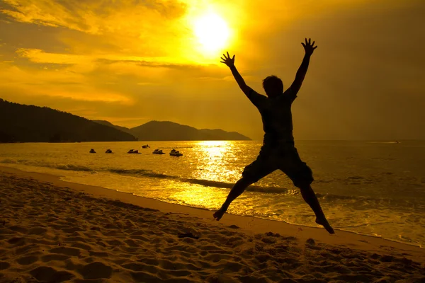 Man skoki na plaży sunset — Zdjęcie stockowe