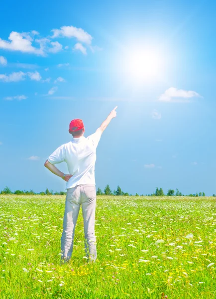 Człowiek na zielonej łące w słoneczny dzień — Zdjęcie stockowe