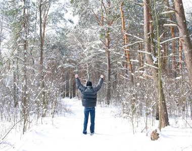 persoon met opgeheven handen in het winter forest