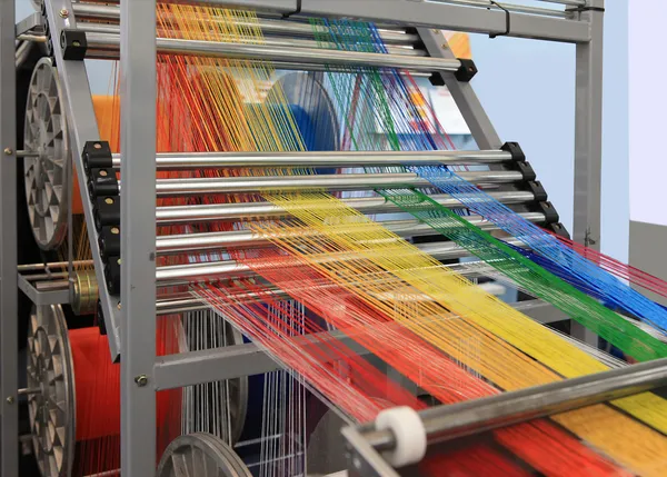 Fios multicoloridos na máquina têxtil — Fotografia de Stock