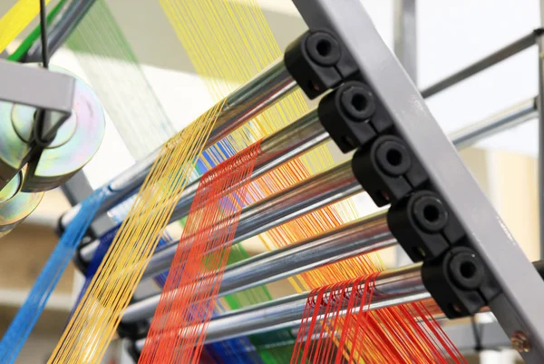 Fios multicoloridos na máquina têxtil — Fotografia de Stock