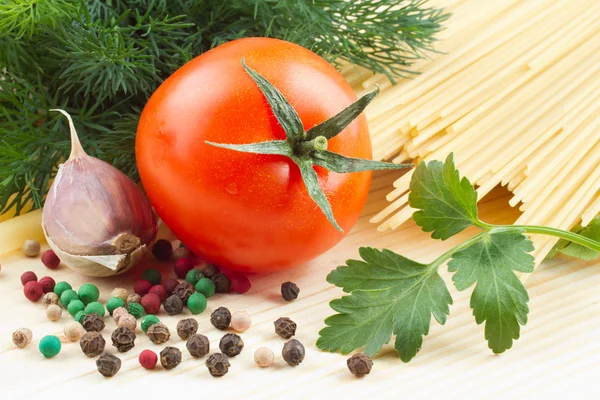 Makarna, domates, dereotu, maydanoz, sarımsak, biber kesme tahtası üzerinde — Stok fotoğraf
