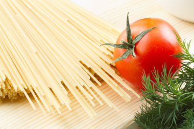 makarna (pişmemiş spagetti), domates, dereotu kesme tahtası üzerinde