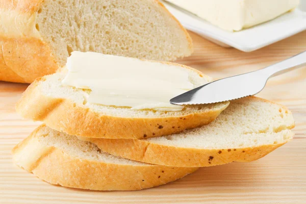 Řezy bageta s máslem na dřevěných bord — Stock fotografie