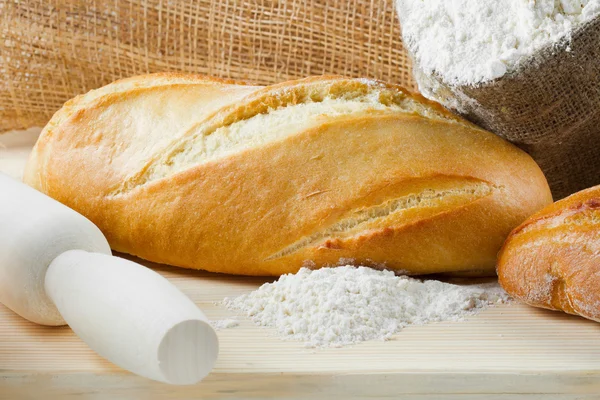 Taze pişmiş baget ve ahşap kesme tahtası, çuvalı o ekmek — Stok fotoğraf