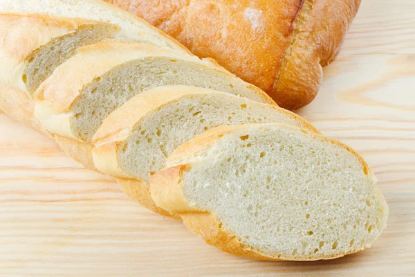 Versgebakken stokbrood gesneden op houten snijplank — Stockfoto