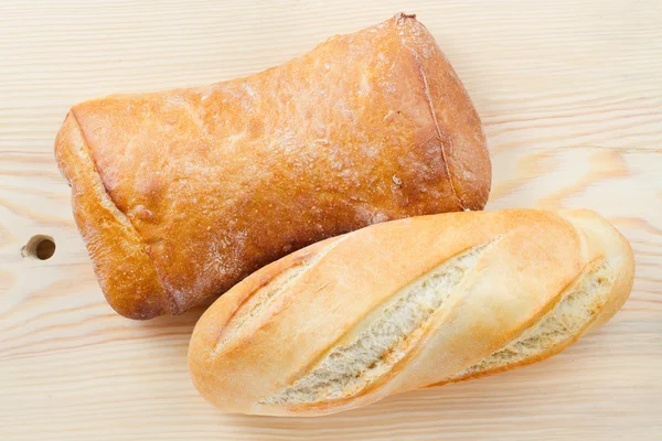 Baguete recém-assada e pão em tábua de corte de madeira, top vi — Fotografia de Stock
