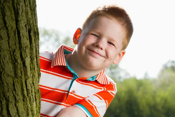 Chłopiec chowa się za drzewem — Zdjęcie stockowe