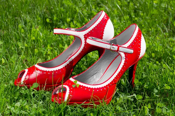 Dişi kırmızı yüksek topuk yaz ayakkabı çimenlerin üzerinde — Stok fotoğraf