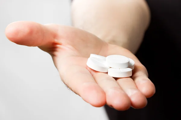 Man holding pills in hand — Stock Photo, Image