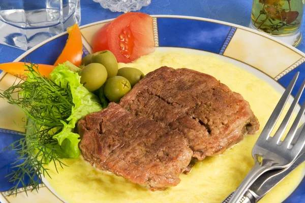 Кусок жареного мяса с соусом и овощами — стоковое фото