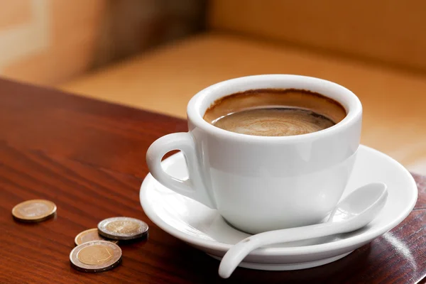 Šálek kávy a peníze na stůl — Stock fotografie