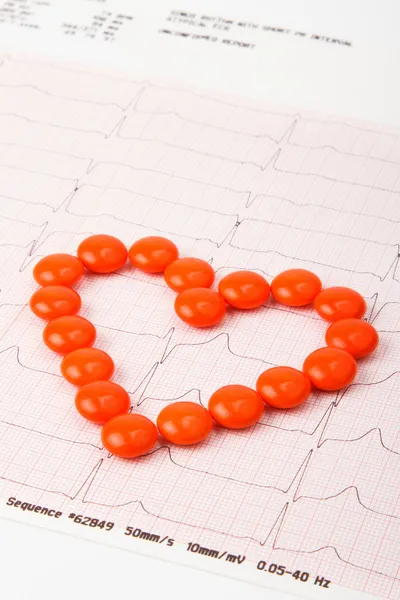Heart of pills on electrocardiogram — Stock Photo, Image