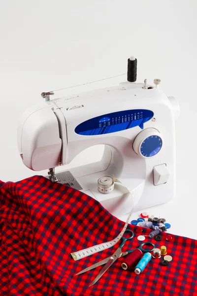 Швейная машина с красной тканью — стоковое фото