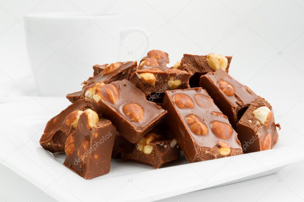 Broken chocolate pieces with nuts on plate