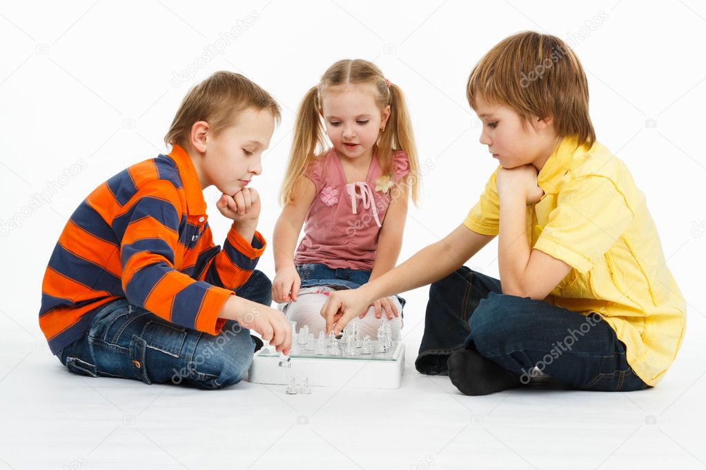Two boys and pretty girl playing chess