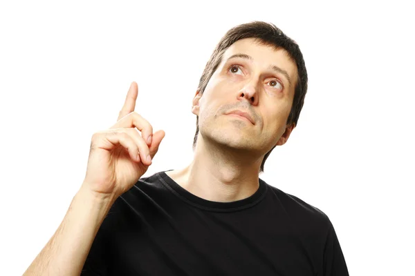 Young man pointing up and looking upwards on white background — Stock Photo, Image