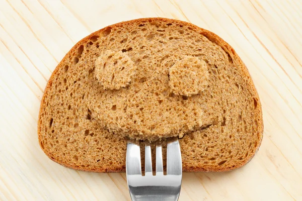 Kromka chleba jak uśmiechnięta twarz — Zdjęcie stockowe