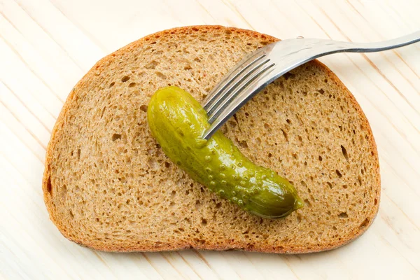 Sneetje brood, komkommer op een vork — Stockfoto