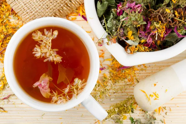 Taza de té saludable, mortero y mortero con hierbas curativas —  Fotos de Stock